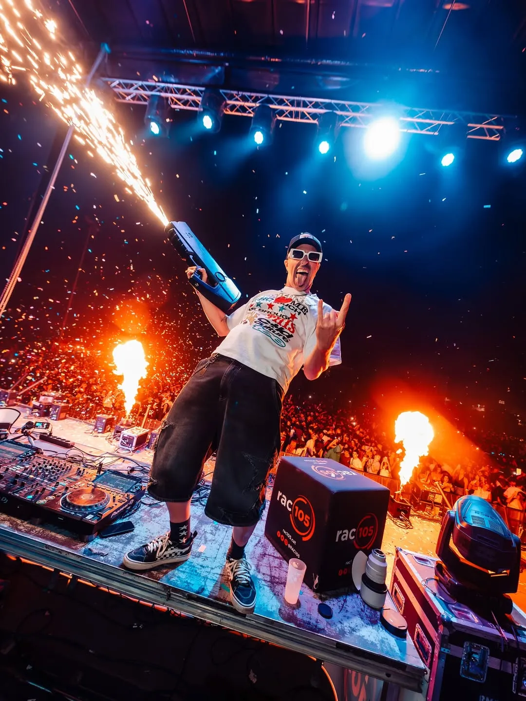 MON DJ a l'escenari entre fum, blau elèctric i una flamarada lateral.