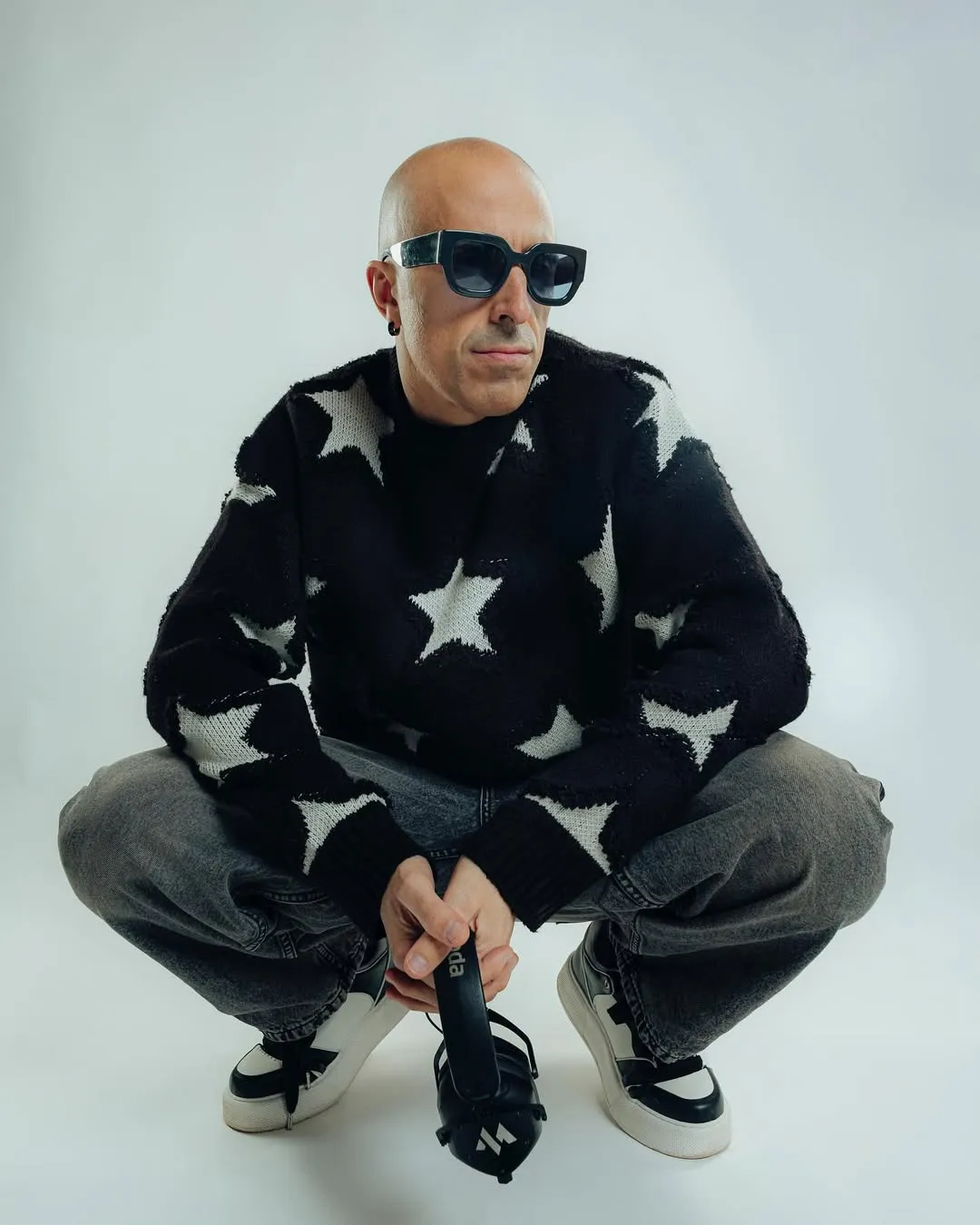 Retrat proper de MON DJ asseguda amb un jersei d'estrelles sobre fons clar.